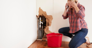 Las Vegas homeowner calling emergency plumber after burst pipe causes wall and water damage